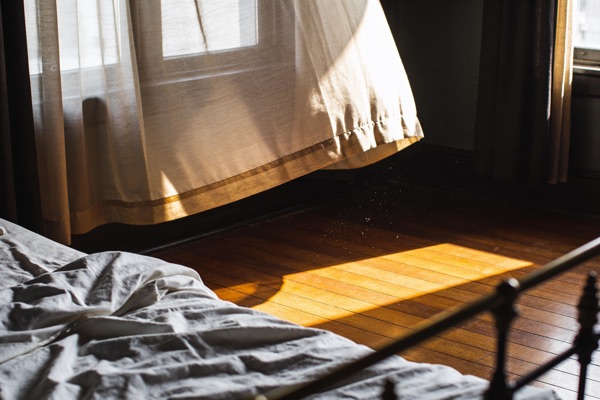 Morning light raking across a quiet bedroom